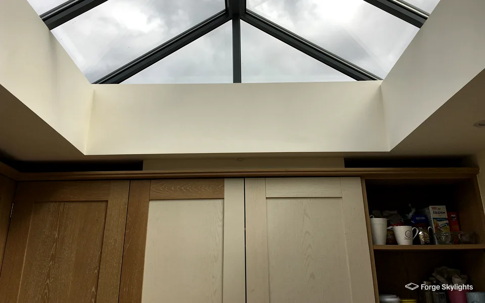 Looking up at a roof lantern above oak kitchen units