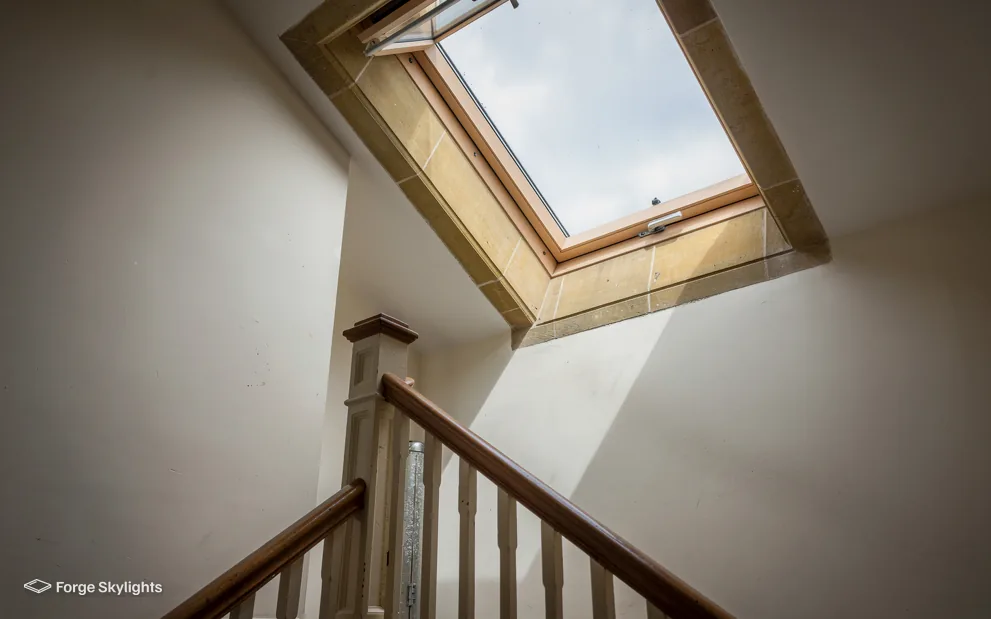 A stair landing with a roof window above
