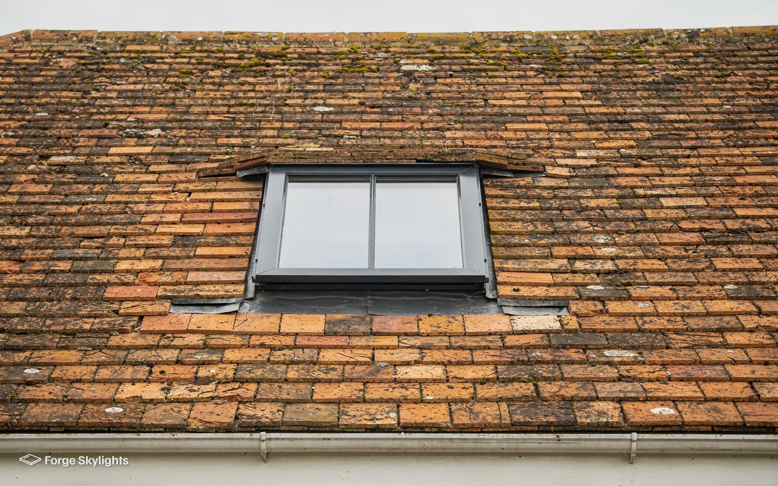 A conservation style rooflight with a central glazing bar set into a clay tile roof