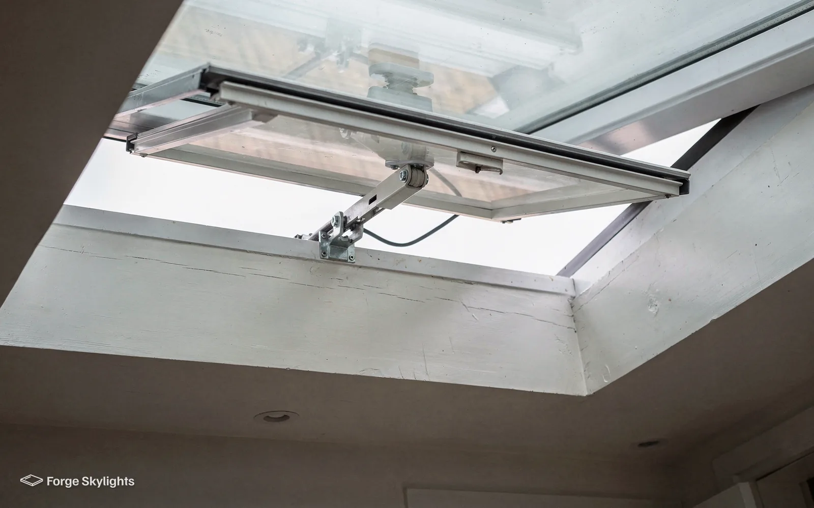 The chain actuator and hinge of an opening rooflight, seen from below