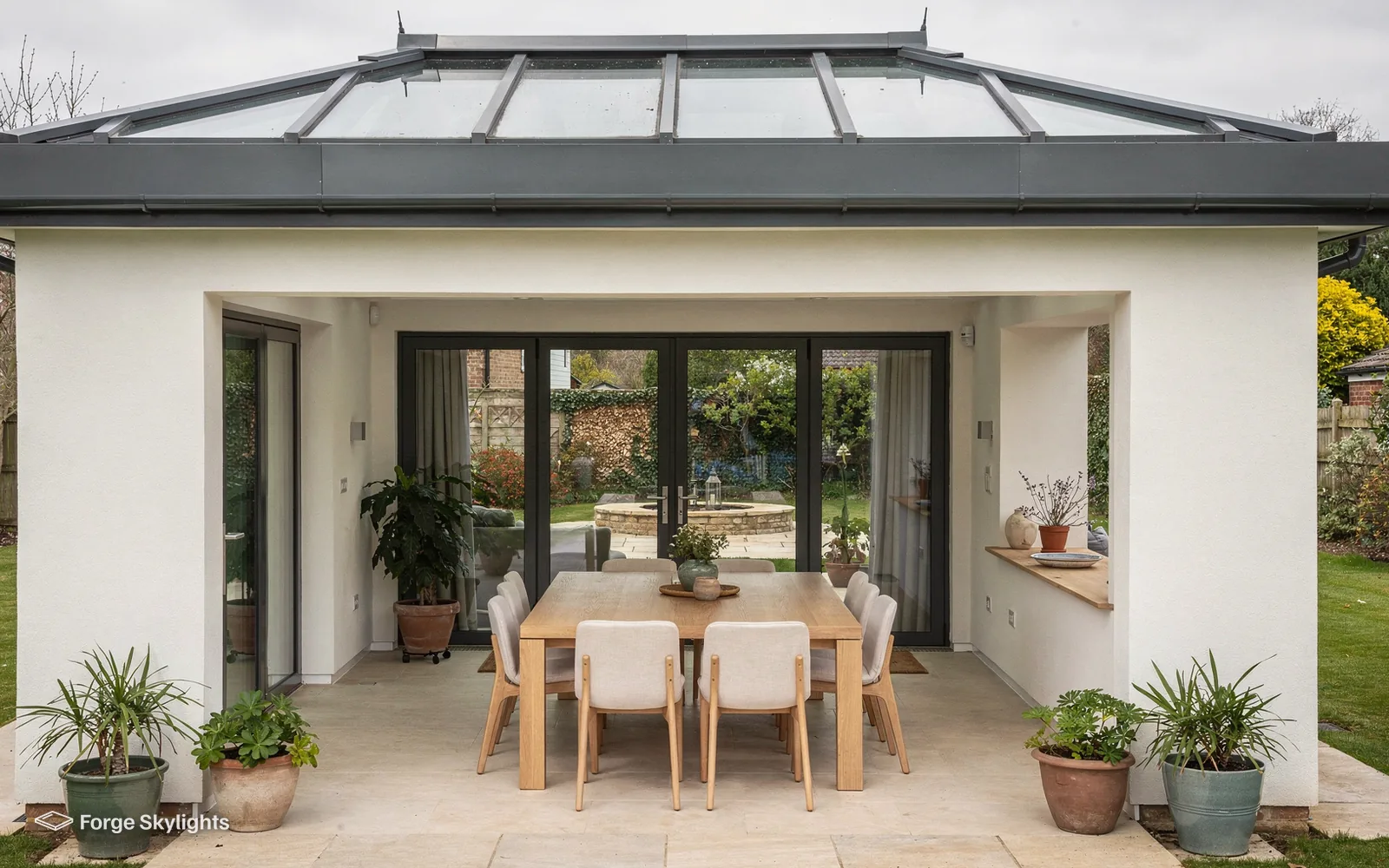 A rendered garden extension with a roof lantern and a dining table inside