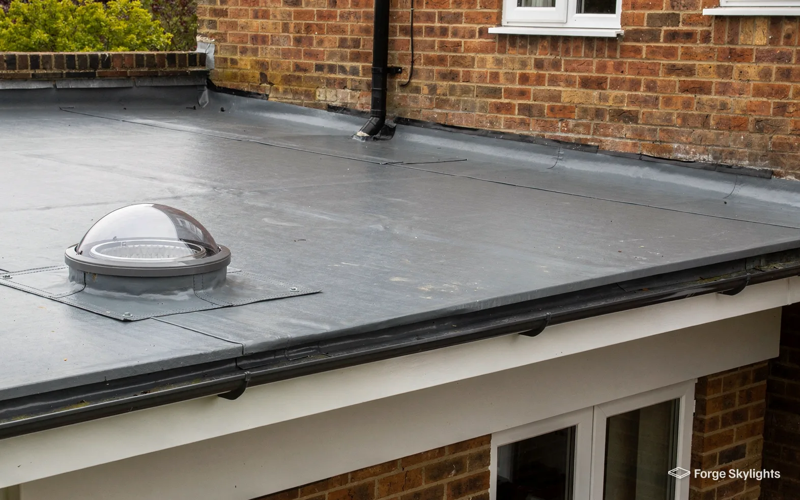 A sun tunnel dome on the flat roof of an extension