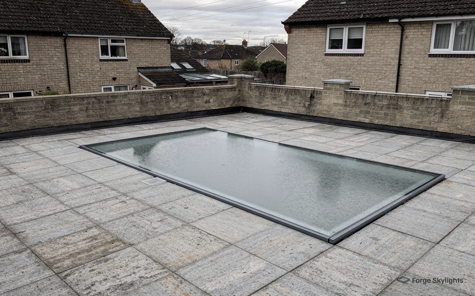 A large walk-on glass panel set in a paved roof terrace